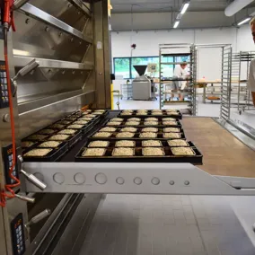 Mitarbeiter der Backstube in Taubenheim schiebt Brotlaibe in den Ofen