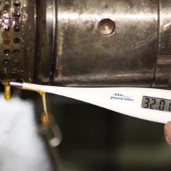 Thermometer misst die Temperatur von frisch gepresstem Öl