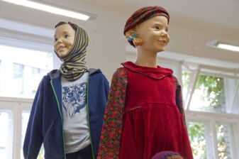 Zwei Modepuppen, die eine Auswahl an Bio-Kinderkleidung tragen