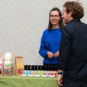 Frau und Mann stehen an einem Stand mit Bio-Produkten