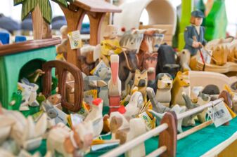 Detailansicht von ökologischen Spielsachen und Holzfiguren im Naturwarenladen