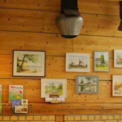 Gerahmte Bilder an der Wand im Hofladen der Käserei Schönborn