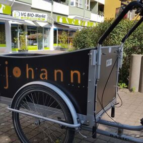 Lastenfahrrad mit Aufdruck 'Johann' Frontseite vor dem Laden Johannstadt
