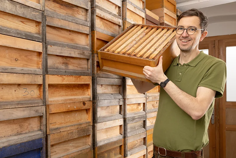 Mann hält einen leeren Bienenkasten. Copyright: KATHARINA_GROTTKER