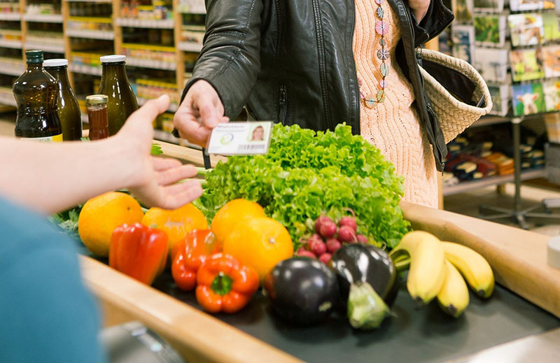 Gemüse-Einkauf auf einem Kassenband, VG-Mitgliedskarte wird vorgezeigt